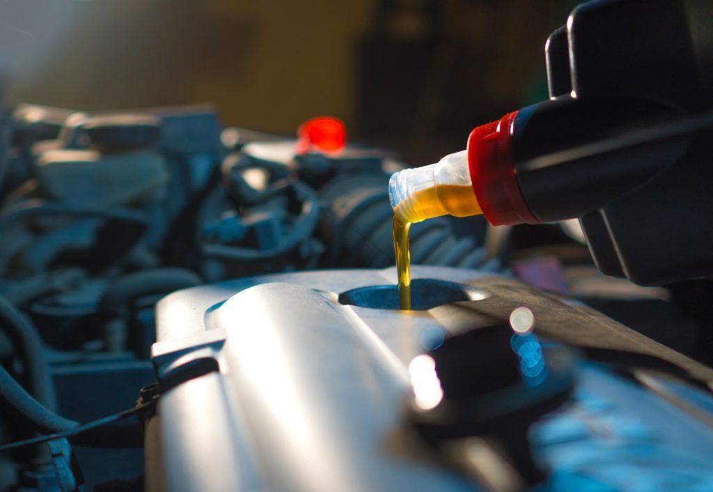 filling oil into valve cover of engine