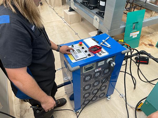 generator service technician load bank testing on blue tester